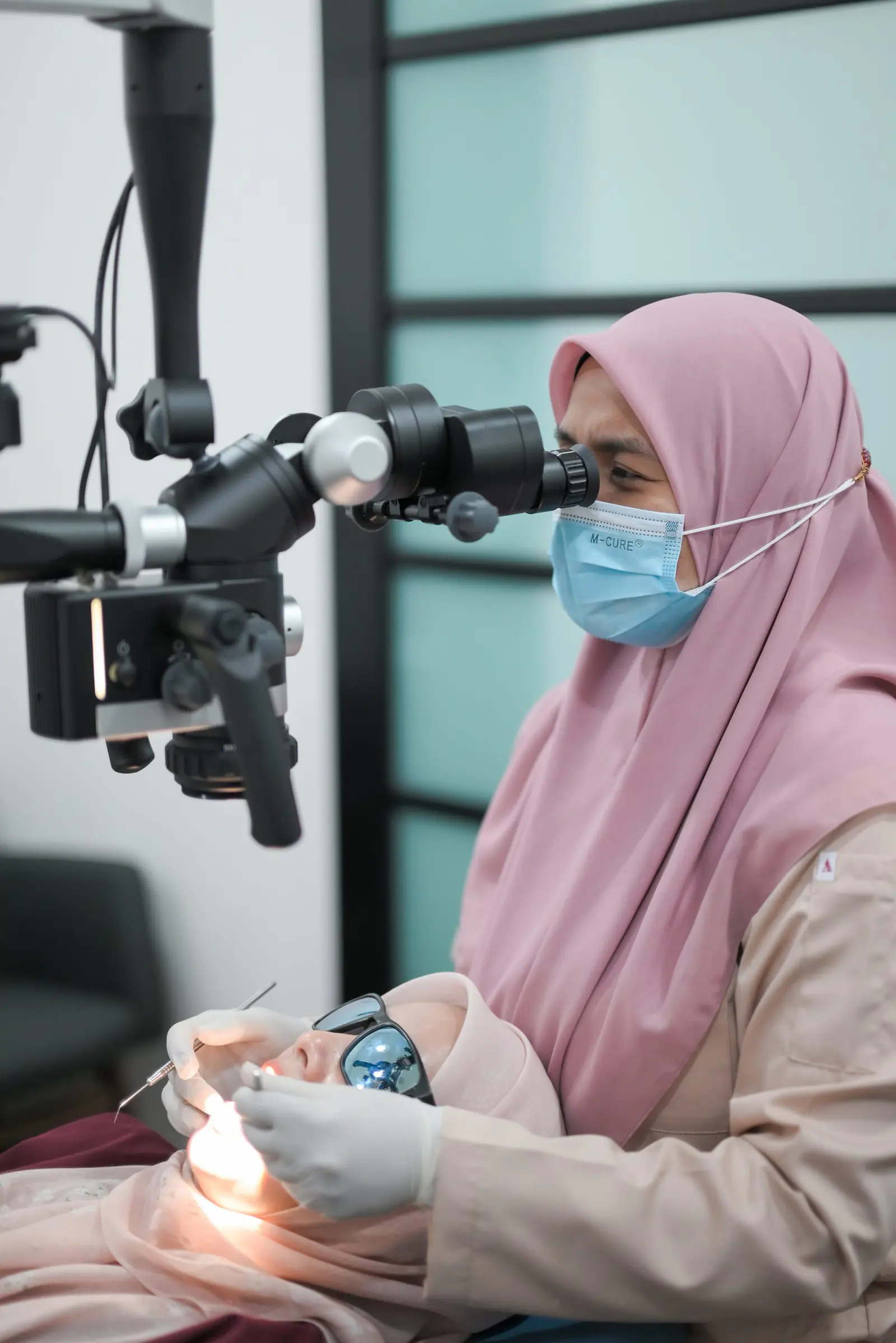 A dentist working with a patient in the treatment room